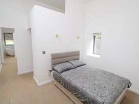 A bedroom with a bed and window at The Cottage in Ballinagleira