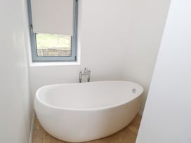 A bathroom with a bathtub and a window at The Cottage in Ballinagleira