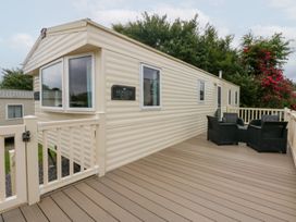 A mobile home with a deck and chairs at Mountain View in Pwllheli