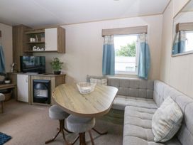 A living room with a table and seating area at Mountain View in Pwllheli