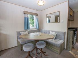 A dining area with a table and benches at Mountain View in Pwllheli