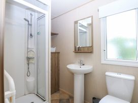 A bathroom with a shower, sink, and toilet at Mountain View in Pwllheli
