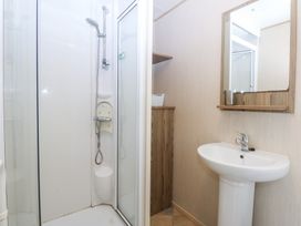 A shower and sink in a bathroom at Mountain View Pwllheli