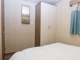 A bedroom with a wardrobe and a mirror at Mountain View in Pwllheli