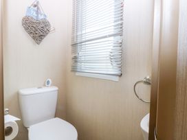 A bathroom with a toilet and window at Mountain View in Pwllheli
