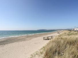 A beach with sand and sea at Mountain View Haven near Pwllheli