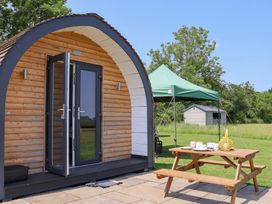 A cabin with outdoor seating and tent at Honeypot Hideaways - Clover