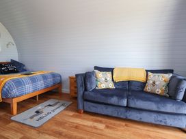 A bedroom with a bed and sofa at Honeypot Hideaways - Clover