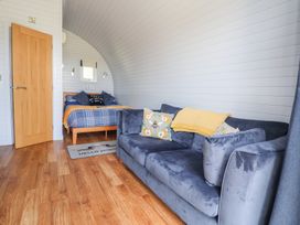 A bedroom with a bed and sofa at Honeypot Hideaways - Clover