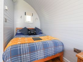 A bedroom with a bed and tablet on it at Honeypot Hideaways - Clover