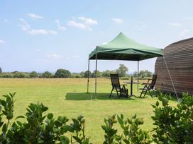 An outdoor space with a tent and chairs at Honeypot Hideaways - Clover