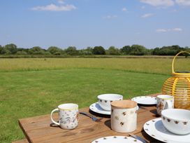 A table set with dishes and a lantern in a field at Honeypot Hideaways - Clover