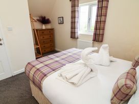 A bedroom with a bed and wooden furniture at Lodge 8 Brigg
