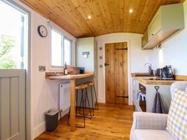 A kitchen with a bar table and stools at Charollais in Oswestry