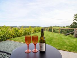 A table with wine glasses and a bottle overlooking the garden at Charollais in Oswestry