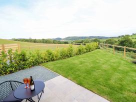 An outdoor area with a table and chairs overlooking the landscape at Charollais in Oswestry