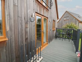 An outdoor patio area with a wooden wall and furniture at Lodge 9 in Brigg