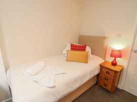 A bedroom with a single bed and bedside table at Lodge 9 in Brigg