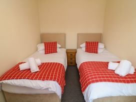 A bedroom with two beds and a bedside table at Lodge 9 in Brigg