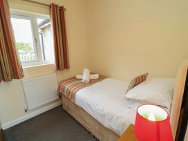 A bedroom with a single bed and a window at Lodge 9 in Brigg