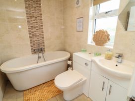 A bathroom with a bathtub, toilet, and sink at Lodge 9 in Brigg