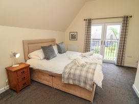 A bedroom with a bed and sliding doors at Lodge 9 in Brigg
