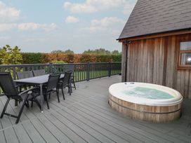 An outdoor patio with a hot tub and dining set at Lodge 9 in Brigg