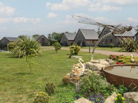 A garden with a pond and sculptures at Lodge 9 in Brigg