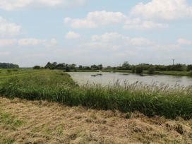A view of a lake surrounded by grass and trees at Lodge 9 in Brigg