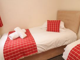 A bedroom with a bed and towels at Lodge 13 in Brigg