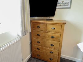 A dresser with a television in a bedroom at Lodge 13 in Brigg