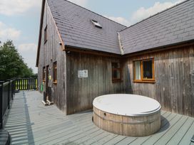 An outdoor area with a hot tub and wooden exterior at Lodge 13 Brigg