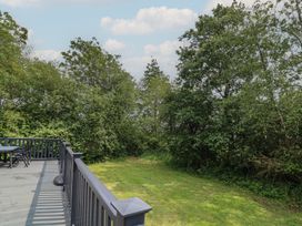 An outdoor area with a deck, table, and chairs at Lodge 13 in Brigg