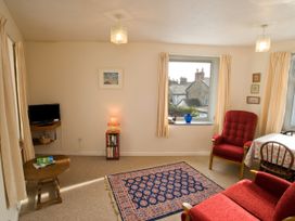 A living room with a television and books on a shelf at Chyancrowse Gulval
