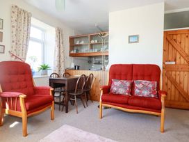 A living room with two red sofas and a dining table at Chyancrowse in Gulval