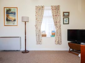 A living room with a lamp, television, and window at Chyancrowse in Gulval