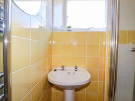 A bathroom featuring a washbasin and yellow tiled walls at Chyancrowse in Gulval