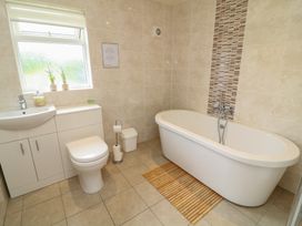 A bathroom with a bathtub, toilet, and sink at Lodge 14 in Brigg