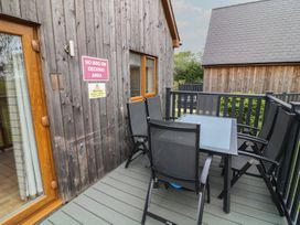 An outdoor decking area with a table and chairs at Lodge 14 in Brigg