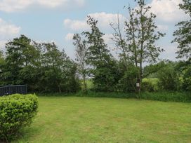 A garden with grass and trees at Lodge 14 Brigg