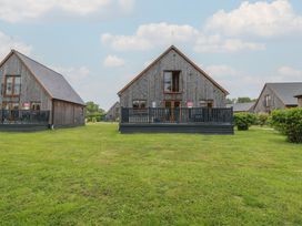 Three houses with balconies and grass area at Lodge 14 in Brigg