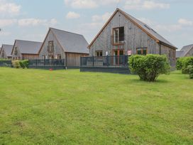 Wooden houses with decking and grass area at Lodge 14 in Brigg