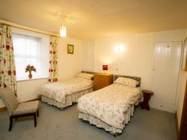 A bedroom with two beds and a chair at Chyandaunce in Gulval
