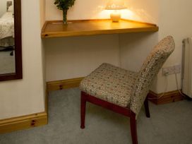 A desk with a chair and lamp at Chyandaunce in Gulval