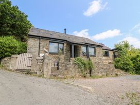 A stone house with a gravel driveway at The Old Barn in Ciliau Aeron near Aberaeron