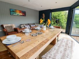 A dining room with a wooden table and chairs at The Old Barn in Ciliau Aeron near Aberaeron