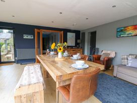 A dining room with a wooden table and chairs at The Old Barn in Ciliau Aeron near Aberaeron
