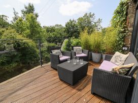 An outdoor patio with chairs, table, and plants at The Old Barn in Ciliau Aeron near Aberaeron