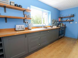 A kitchen with blue walls and wooden countertop at The Old Barn in Ciliau Aeron near Aberaeron