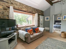 A living room with a sofa and television at The Old Barn in Ciliau Aeron near Aberaeron